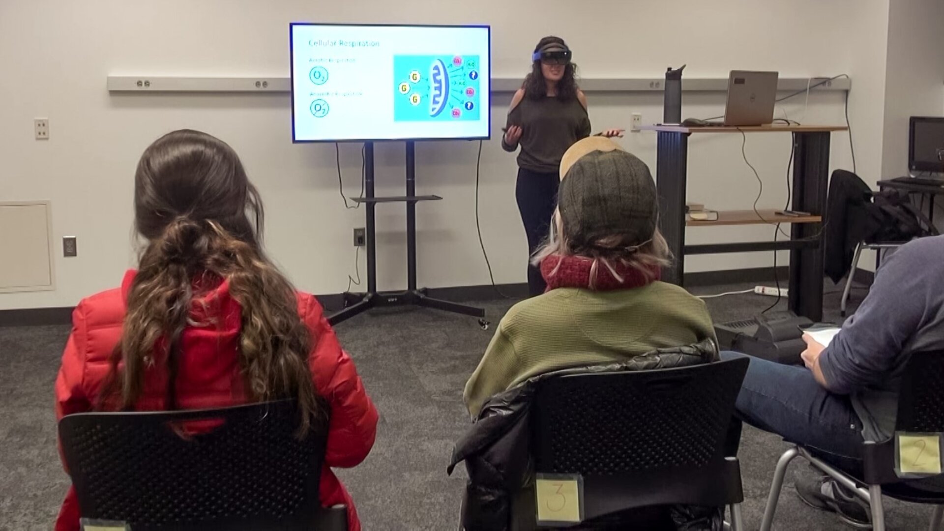 A presenter using the HoloLens AR presentation system during a presentation in front of an audience.